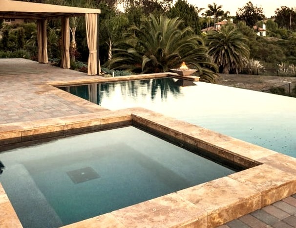 Mid-sized tuscan backyard brick and rectangular infinity hot tub photo